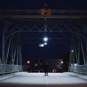 Teen walking on dark bridge