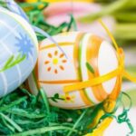 Colored eggs in a basket filled with fake grass