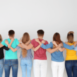 Back group shot of teens putting arms around each other