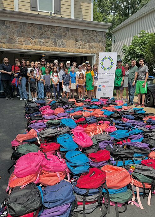 Group of people standing in front of backpacks