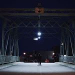 Teen walking on dark bridge
