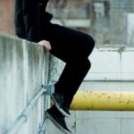 Teen Sitting on Low Wall